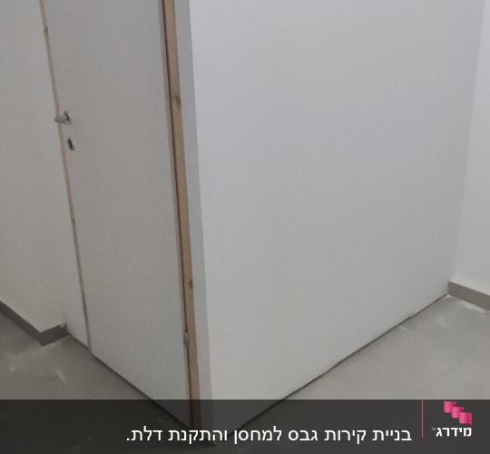 קיר גבס לבן עם דלת עץ צמודה